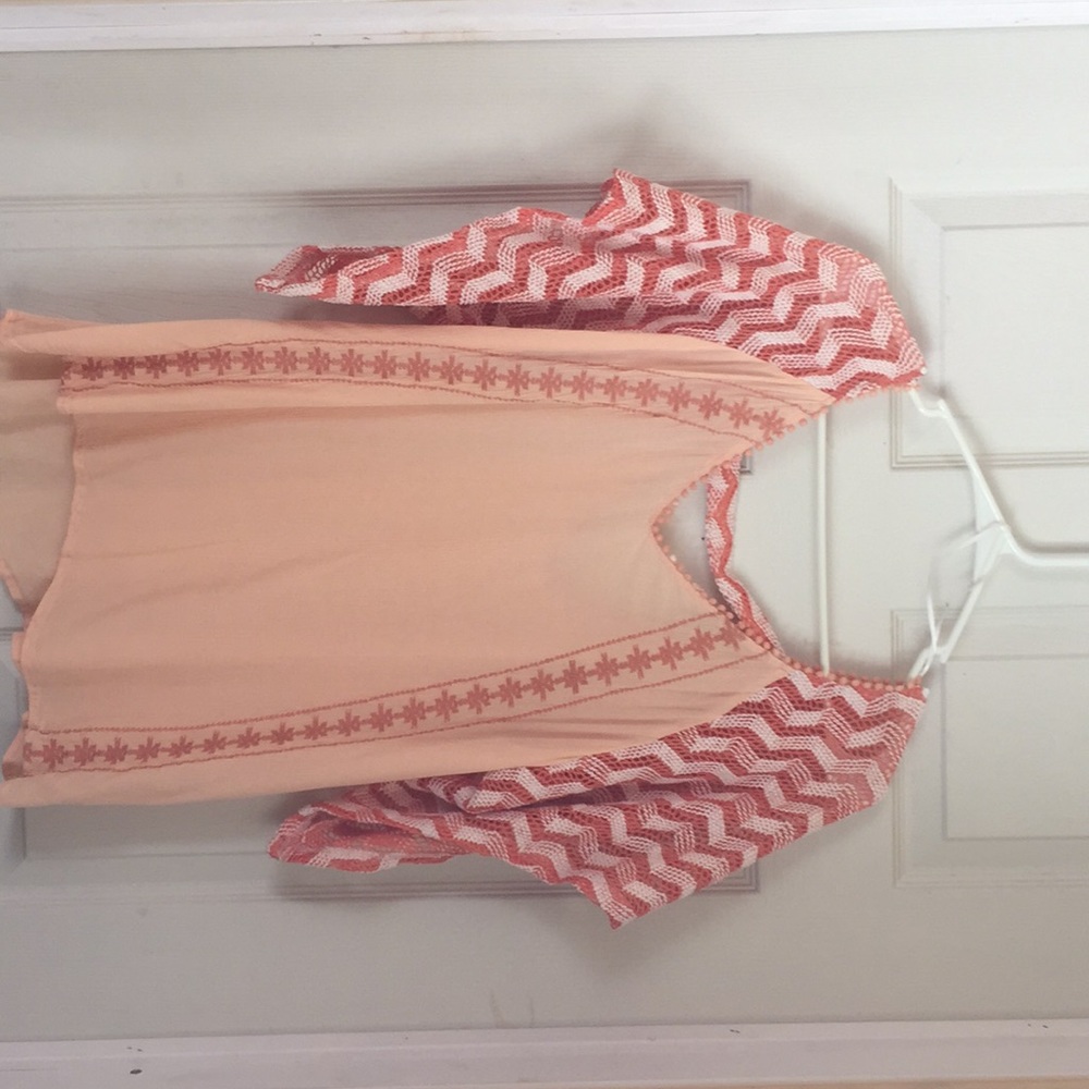 Light orange blouse with chevron sleeves.